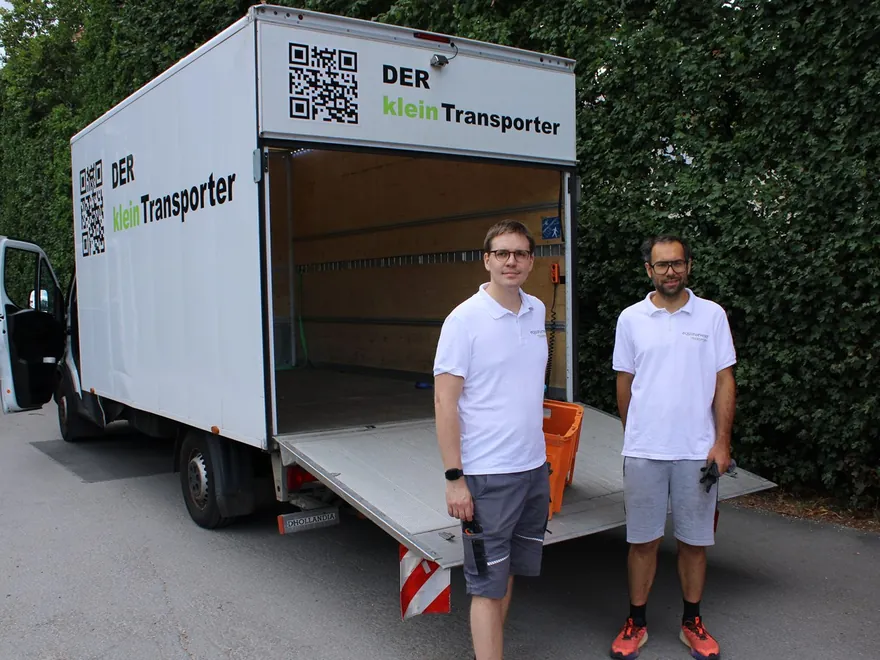 Das Team von DER kleinTransporter vor dem geöffneten Firmenfahrzeug